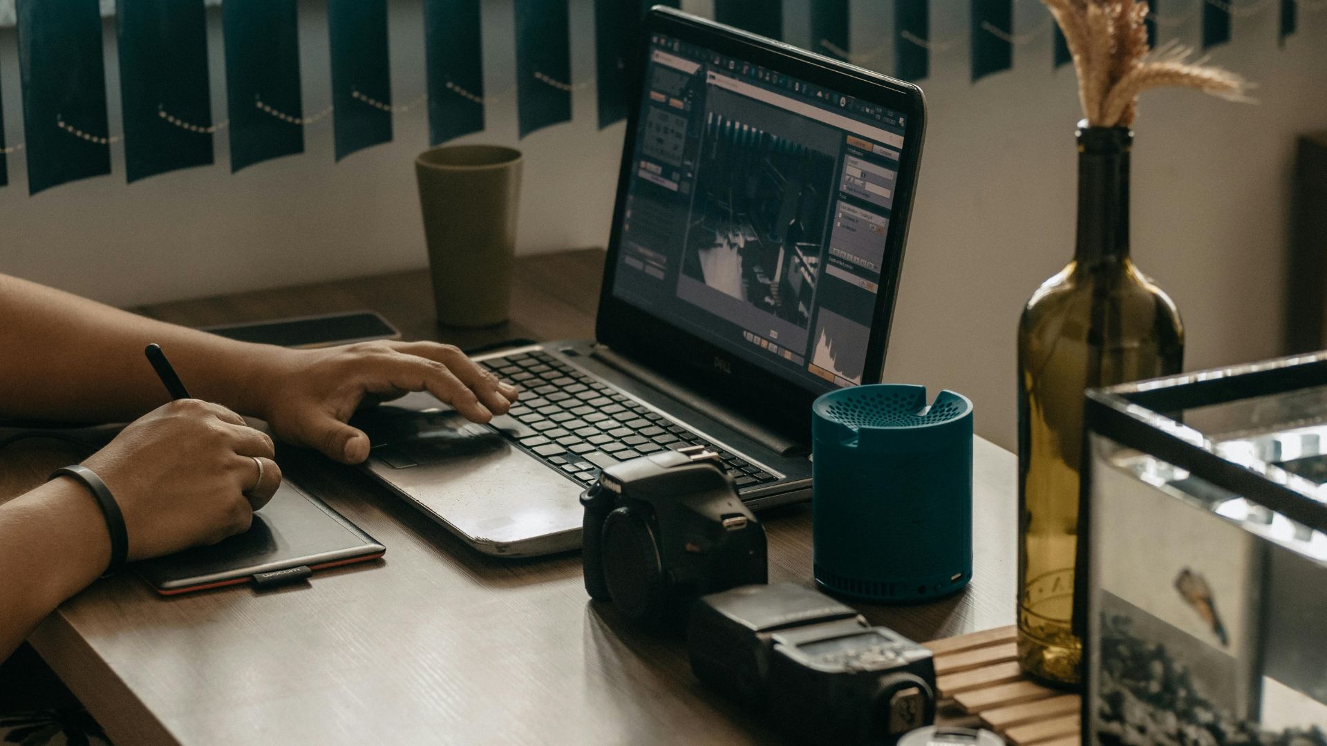 Content creator working on laptop with camera and creative tools