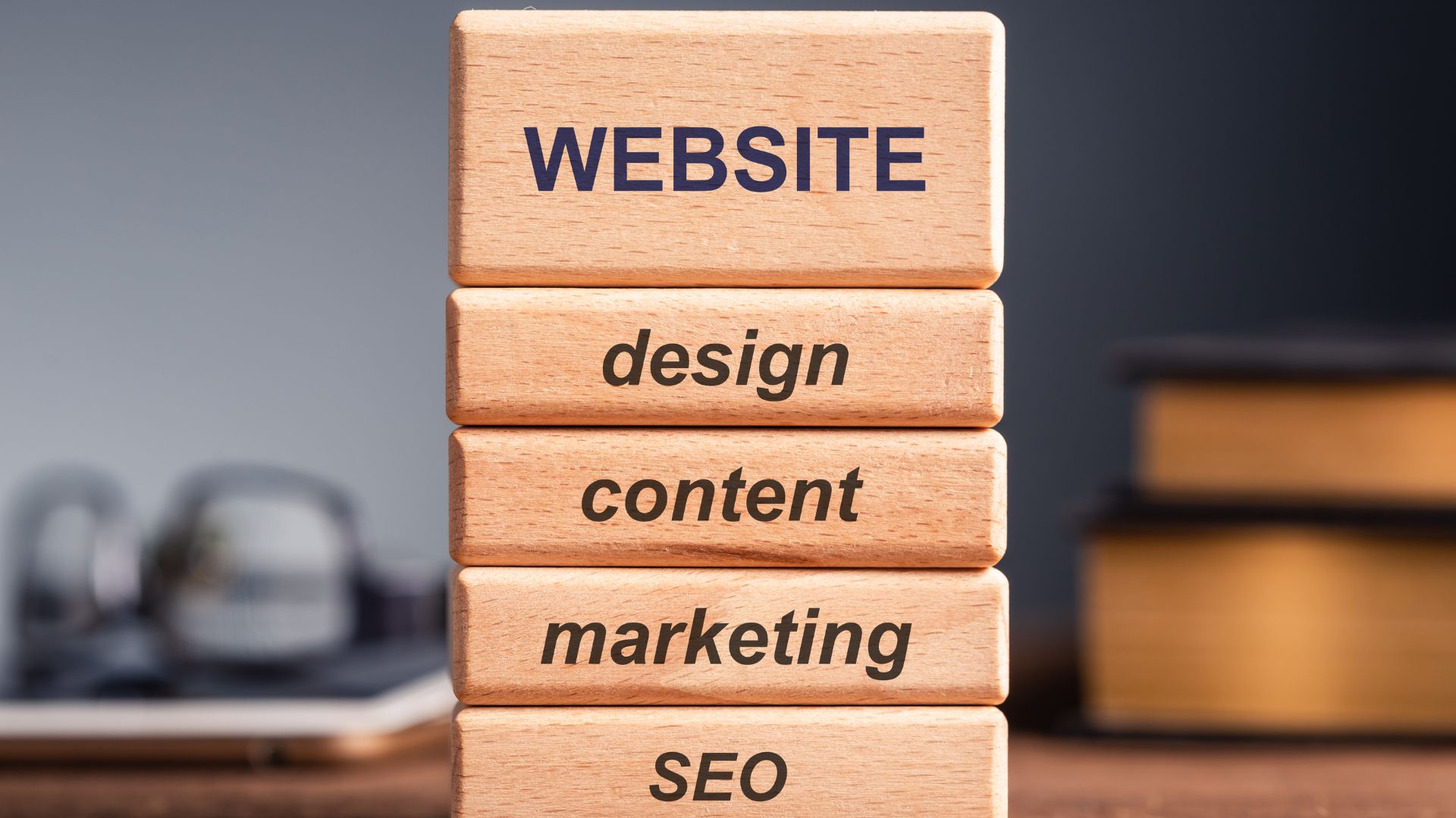 Wooden blocks showing SEO strategy pillars: website, design, content, marketing, and SEO
